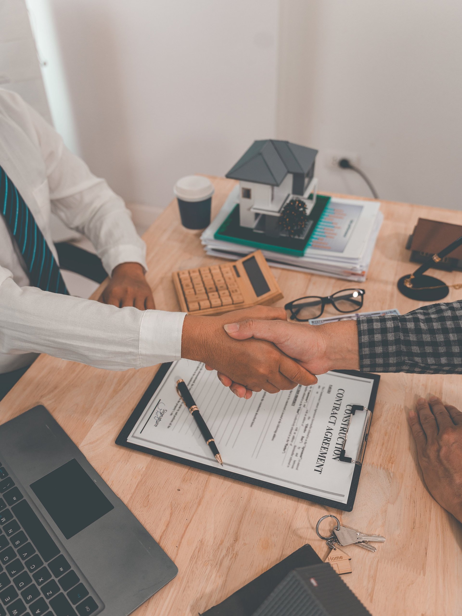 Real estate agent and client shake hands after completing a contract at closing